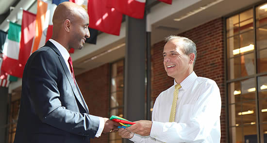 Dawit Lemma, CEO Krimson Aviation (left), presents the Ethiopian flag to Tom Frooninckx, Interim Head of SATT, Purdue University | Photo: John O'Malley, Purdue Polytechnic Institute.