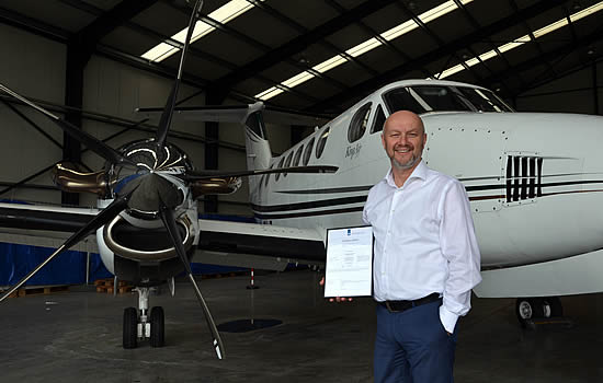 Herman van Kranenburg with Zeusch AOC in hand in front of a Zeusch King Air B200