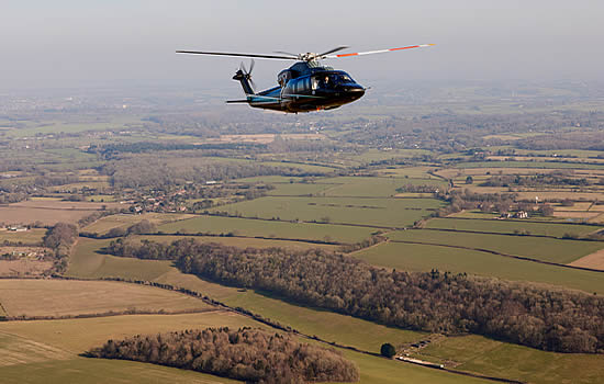 Flexjet Sikorsky S-76 over UK countryside.
