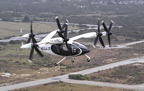 Joby test pilot James “Buddy” Denham flying a fully transitioned Joby aircraft above the company’s facilities in Marina, California